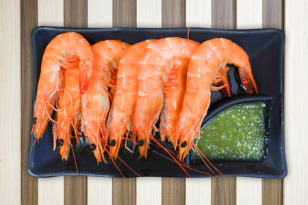 Die cut of boiled fresh shrimp on brawn color wood strip background.の写真素材