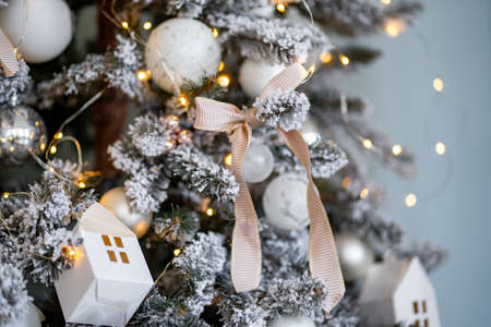 close-up of snowy christmas tree, decorated balls, garland, candles, snowballs