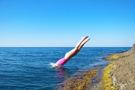 girl jumps into the waterの写真素材