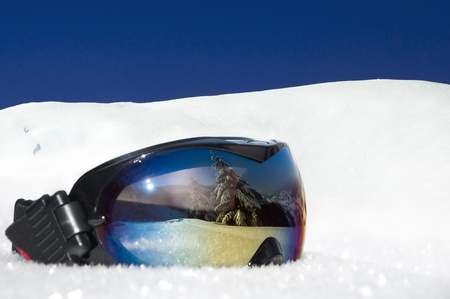 protective eyewear for winter sports and recreation on the background of snowy mountains and blue skyの写真素材