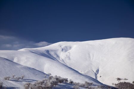 Snow-covered high mountains of Alp in winter against the blue skyの写真素材