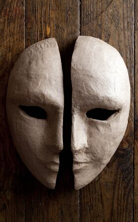 two halves of the paper masks on a wooden backgroundの写真素材