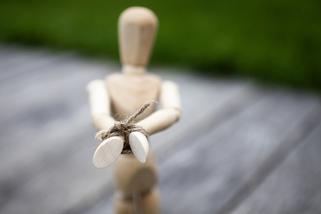 sad wooden dummy hands on the rope hand, outsideの写真素材