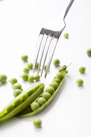 still life of fresh, ripe peas with peas on a white background, with a forkの写真素材