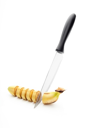 sharp knife, cut into pieces of banana on a white backgroundの写真素材