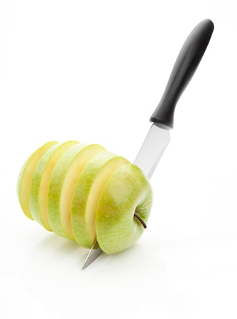 sharp knife, cut into pieces of green apple on a white backgroundの写真素材