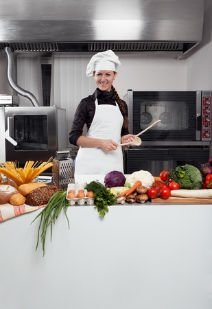 Professional female chef having fun and joy in a professional kitchenの写真素材