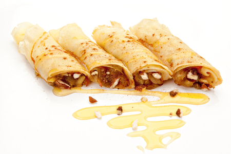 pancakes stuffed with nuts, apples, covered with honey on a white backgroundの写真素材