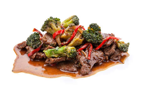 portion of grilled meat with vegetables in sauce on a white backgroundの写真素材