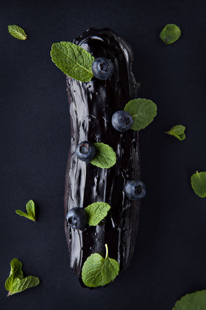 exquisite cream dessert eclair with blueberry and fresh mint leaves
