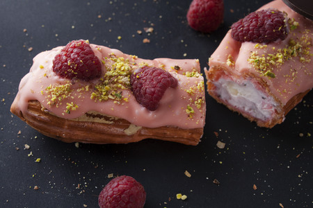 exquisite cream dessert eclair with fresh raspberryの写真素材