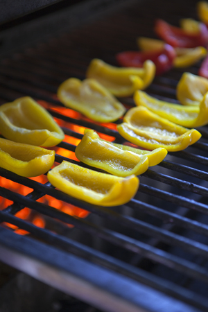 roasted yellow and red peppers on the grillの写真素材