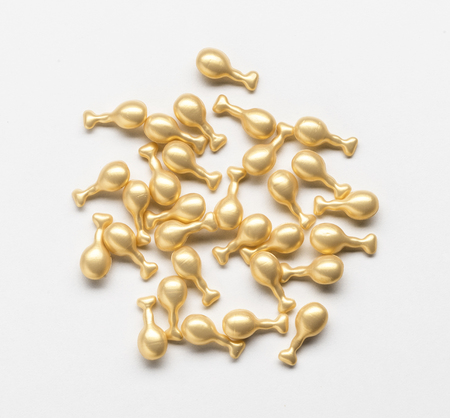 Golden capsule with a cream for face treatment on white backgroundの写真素材