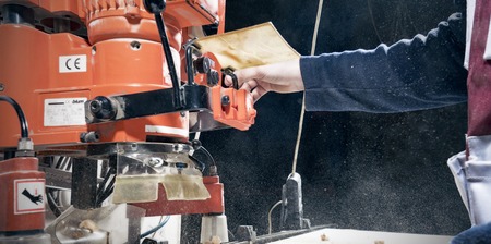 Men's hands at work behind a modern joinery machineのeditorial素材
