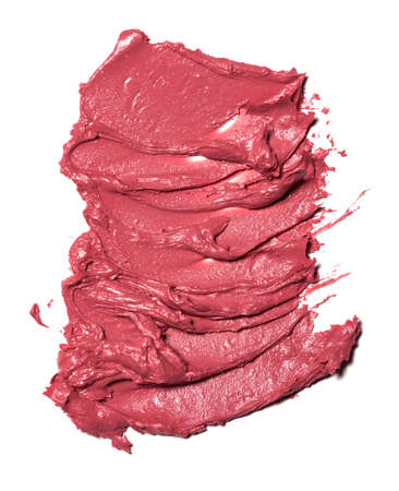 Collection of pink smear crushed cosmetic products on a white background
