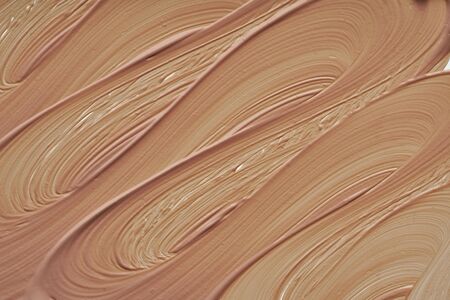 Gently beige strokes and texture of makeup foundation or acrylic paint isolated on white backgroundの写真素材