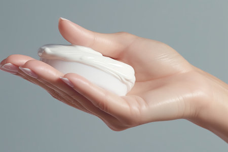 This compelling image offers a closeup view of a mid-age woman's hands delicately taking a specialized face cream for older skin with her fingertip. The advertising concept focuses on the benefits of anti-wrinkle, anti-aging, whitening, rejuvenation, and UV protection for women in menopause. The image captures the essence of self-care and skincare rituals, emphasizing the importance of proper treatment and nourishment for mature skin. The hands gently applying the cream highlight the tactile experience and evoke a sense of rejuvenation and well-being. Perfect for promoting skincare products targeted towards older women, anti-aging treatments, and the empowerment of women in embracing their natural beautyの素材