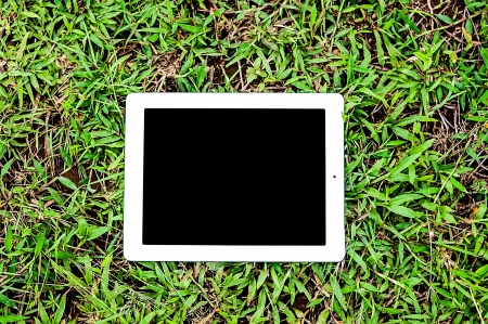 tablet computer on green grassの写真素材