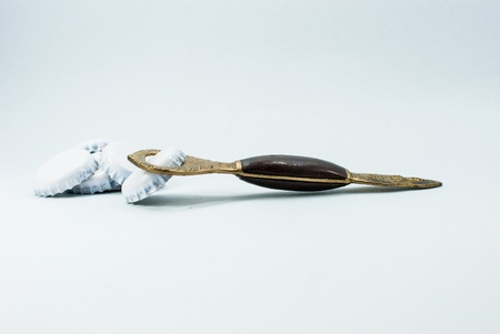 Close up of a golden bottle opener pattern Thailand and white bottle capsの写真素材