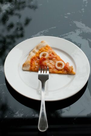 Seafood Pizza Slice in white dish on a black backgroundの写真素材