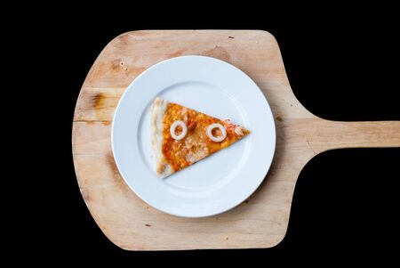 Seafood Pizza Slice in white dish on a black backgroundの写真素材