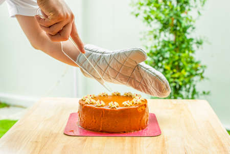 Men cutting the thai tea layer cake on the tableの写真素材