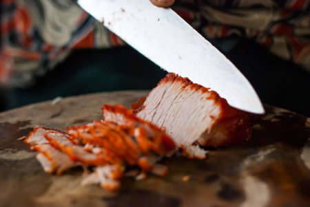 Are being sliced Roasted red pork on a cutting board の写真素材