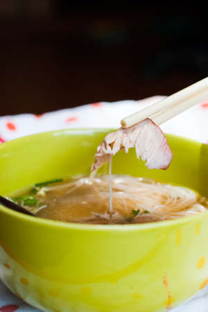 Roasted red pork with noodle In a green bowl.の写真素材