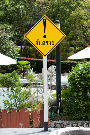 a yellow danger sign in the gardenの写真素材