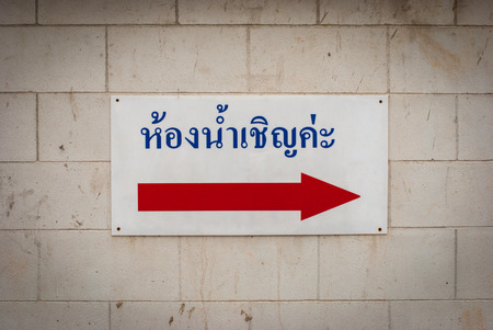 Ancient toilet sign with Arrow on cement wallの写真素材