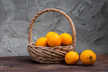 Wicker basket with orange on a Cement Grey backgroundの写真素材