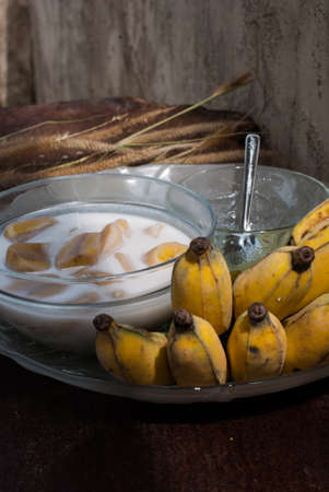Banana in coconut milk put on wood table,Thai desertの写真素材
