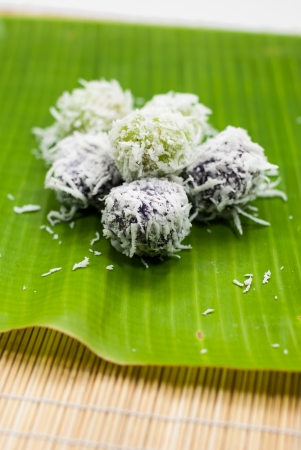Thai dessert sweet boiled ball , roll over the grated coconut on  banana leafの写真素材