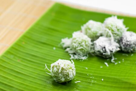 Thai dessert sweet boiled ball , roll over the grated coconut on  banana leafの写真素材