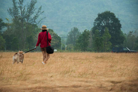 Women walking with dog at the meadow at Ranong Thailandの写真素材
