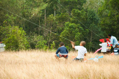 young boys with kite at Mountain grass in Ranong Thailandの写真素材