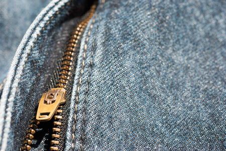 Zipper close-up on blue jeans texture, background