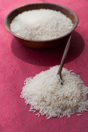 Uncooked white rice on red backgroundの写真素材