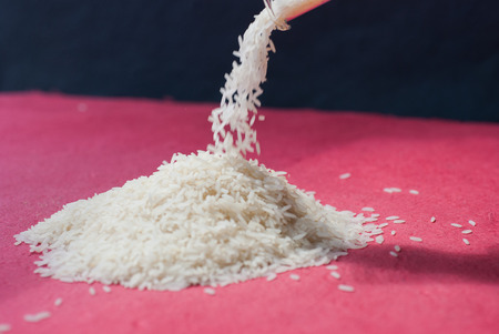 Uncooked white rice on red backgroundの写真素材