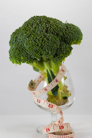 Vegetables, broccoli with a tape measure and glass isolated on whiteの写真素材