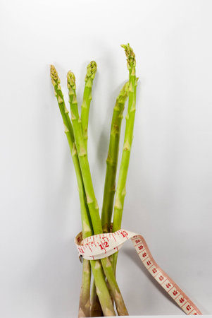 Asparagus with tape measure on the white background Close upの写真素材