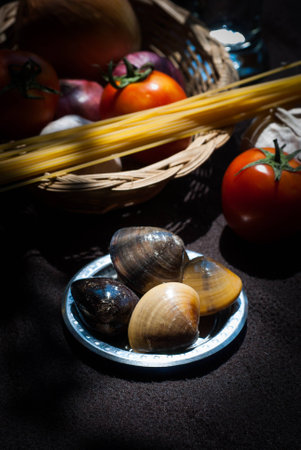 uncooked pasta and tomatoes , cartridge shells , garlic with Onions food closeupの写真素材