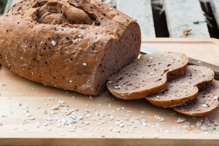 Several slices of Bread wheat and wooden chopping board , Close up