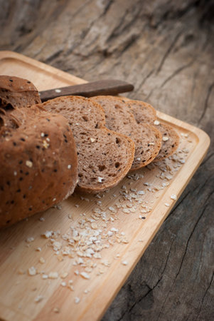 Several slices of Bread wheat and wooden chopping board , Close up
