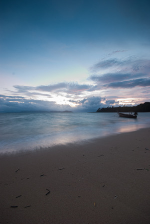 Boat on the beach at sunrise in tide time morningの写真素材