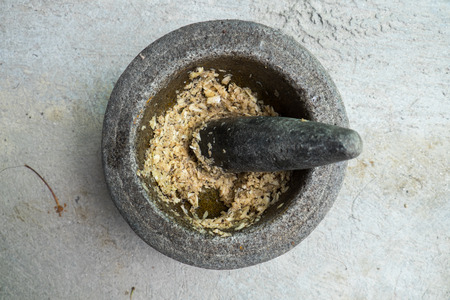 old granite mortar with pestle and garlic,Thailandの写真素材
