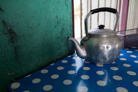 Antique Kettle on blue tableの写真素材