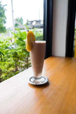 Chocolate milkshake with banana on wooden tableの写真素材