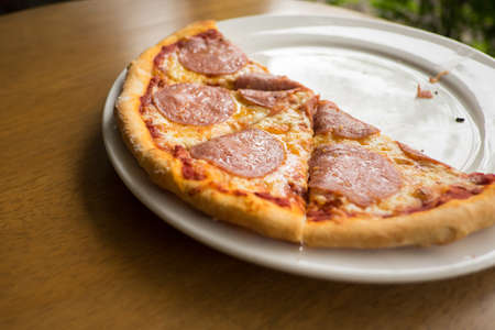 sliced salami pizza on a white plate,home madeの写真素材