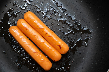 Fried sausages in a pan for breakfastの写真素材